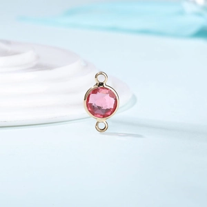 Macro shot of pink crystal birthstone connector with gold plating for jewelry making