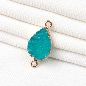 Vista detallada del colgante de cuarzo druzy azul pavo real con bordes dorados para joyería