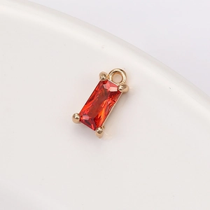 Detailed close-up of a red rectangular crystal pendant with a light gold four-claw setting