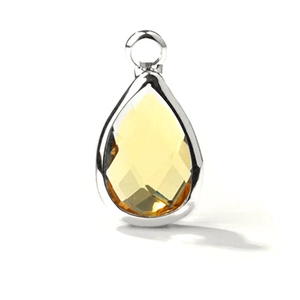 Detailed view of teardrop yellow crystal pendant with faceted glass and silver-tone bezel