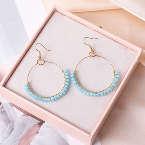 Boho-Ohrringe mit türkisfarbenen Perlen und goldenem Ring in rosa Schmuckbox