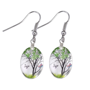 Ethnic style silver earrings featuring handmade glass pendants with tree and butterfly art