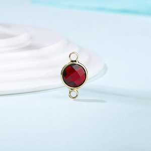 Macro shot of faceted red crystal gemstone connector in gold bezel for DIY jewelry