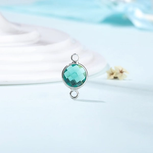 Macro shot of double-loop teal birthstone connector charm for DIY jewelry making