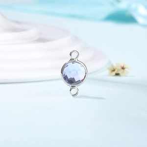 Detail view of double-loop round crystal connector for DIY jewelry in light blue