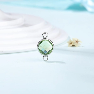 Detail of silver dual-loop connector with faceted light green crystal for DIY jewelry