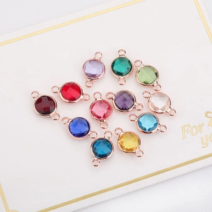 Macro view of multi-colored round birthstone crystal pendants in rose gold settings