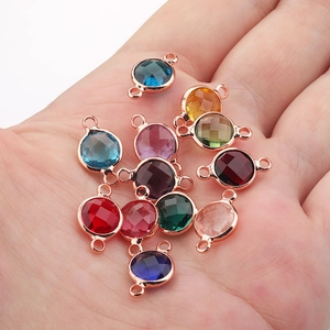 Detailed view of colorful multi-faceted glass birthstone pendants with rose gold rings