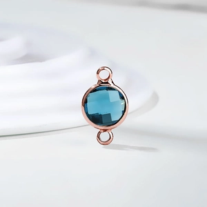 Detailed macro of a sea blue crystal faceted pendant in rose gold finish double loops