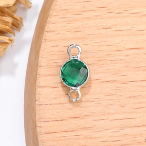 Close-up van 6mm smaragdgroene geboortesteen hanger met zilveren metalen lussen