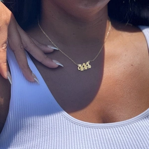 Gold angel number 444 pendant necklace in titanium steel on a fashion model