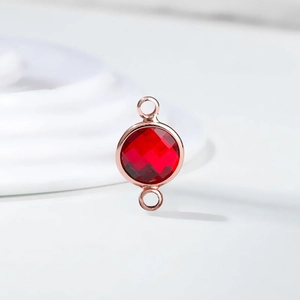 Detail of red birthstone crystal pendant with rose gold double rings for DIY jewelry