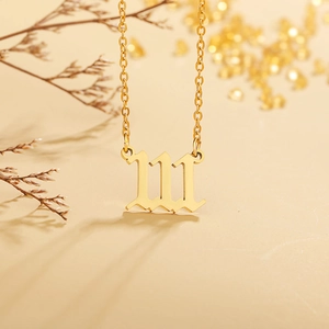 Detailed view of gold stainless steel 111 angel number pendant on fine curb chain