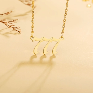 Macro detail of gold-plated 777 angel number pendant with a polished mirror finish