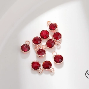 Detail of red 6mm birthstone crystal pendants with rose gold metal frames for DIY jewelry