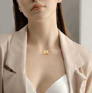 Detailed view of model wearing a gold 111 angel number necklace on a fine link chain