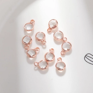 Macro detail of 6mm round glass charms with rose gold copper plating for DIY jewelry making