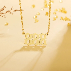 Close-up of golden number 888 pendant with gothic font and polished stainless steel finish