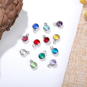 Flat lay of 6mm faceted crystal charms with silver metal rings on white background
