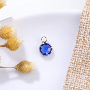 Macro shot of 6mm blue crystal birthstone pendant with silver metal base for DIY jewelry