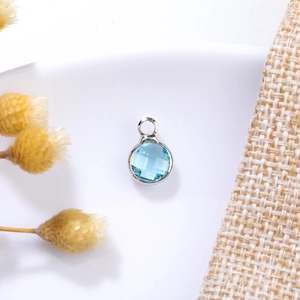 Detailed view of sky blue 6mm birthstone crystal pendant with silver metal bezel setting