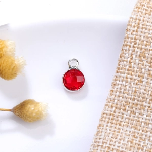 Detailed macro view of 6mm red faceted glass charm with silver metal ring for DIY jewelry