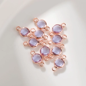 Detail van 6mm lichtpaarse kristallen geboortesteen bedeltjes met roségouden dubbele lussen
