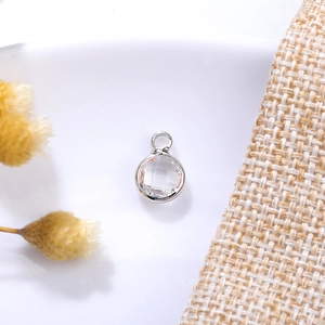 Detailed view of silver bezel set 6mm clear crystal charm with top hanging loop