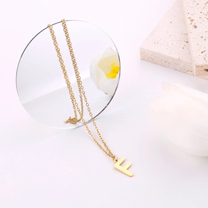 Dettaglio della collana con ciondolo lettera F dorata e finitura lucida elegante