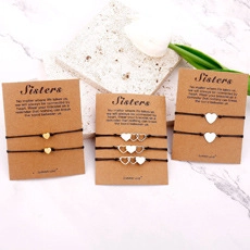 Tre braccialetti dell'amicizia per sorelle con cuori su schede regalo in kraft