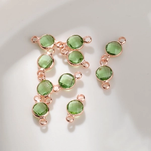 Macro-opname van smaragdgroene kristallen DIY-verbinders met roségouden lussen