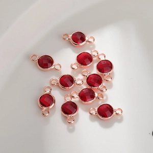Detail van 6mm robijnrode geboortestenen met roségouden dubbele lus connectoren