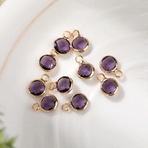 Close-up of 6mm faceted purple glass birthstone pendants with gold copper plating
