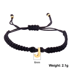 Detail view of woven black string bracelet with 6mm golden letter J charm and 2.1g weight