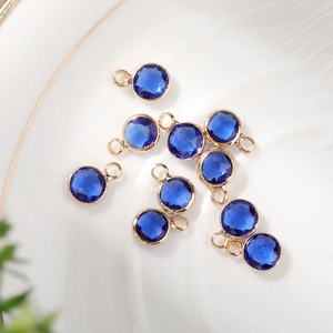 Detail of 6mm deep blue faceted birthstone charms with gold copper plating for DIY