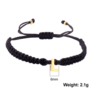 Detail of adjustable black woven bracelet with 6mm gold letter L charm and 2.1g weight