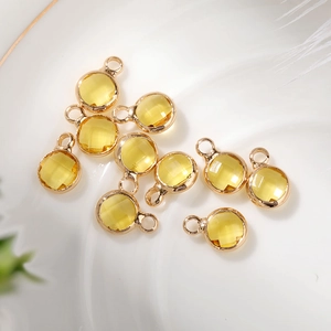 Close-up of 6mm faceted yellow glass charms with gold bezel for DIY jewelry making