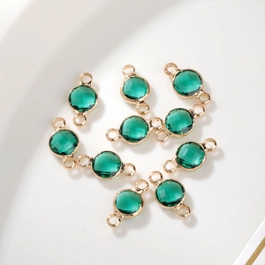 Detail van een 6mm groene geboortesteen hanger met vergulde dubbele oogjes voor DIY