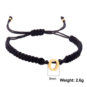Detail of 9mm golden letter O charm on black braided cord bracelet with adjustable beads