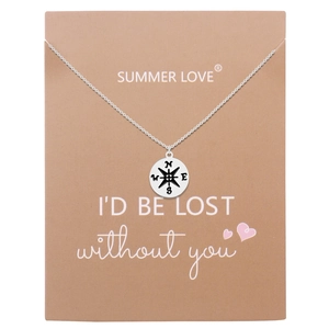 Detail of silver compass pendant necklace on brown gift card with emotional quote