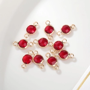 Detail van rode 6mm geboortesteen bedeltjes met gouden dubbele lussen voor DIY sieraden