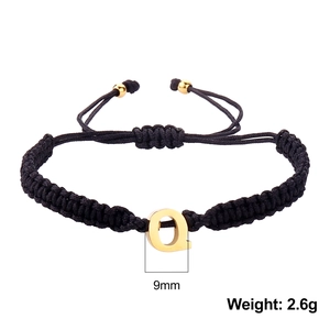 Detail of black braided rope bracelet with 9mm gold letter Q charm and 2.6g weight