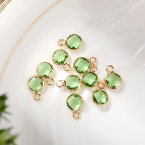 Macro shot of 6mm light green faceted crystal birthstone charms with gold plated frames