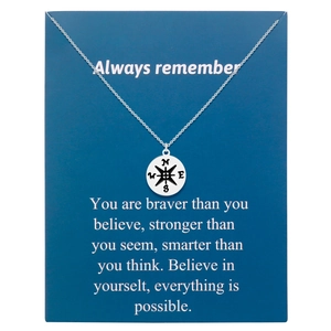 Macro shot of silver compass pendant on a blue inspirational card for men and women