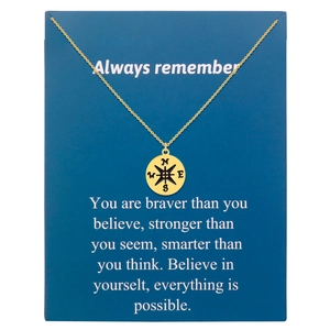 Golden compass pendant necklace displayed on a dark blue gift greeting card