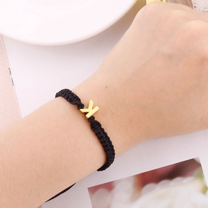 Handmade woven black rope bracelet with a gold letter K charm for men and women