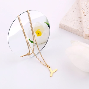 Dettaglio di una collana in acciaio inossidabile dorato con ciondolo a lettera Y e decoro
