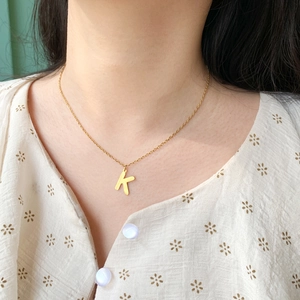Collana in acciaio inossidabile dorato con ciondolo lettera K su una catena minimalista
