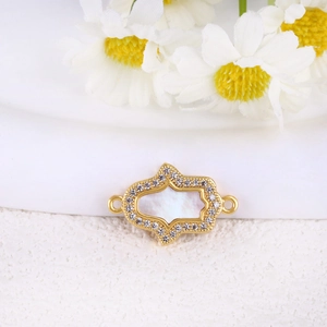 Detail of Hamsa hand connector with gold plating, white shell inlay, and zircons