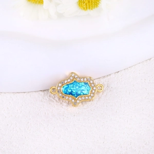 Detailed macro of gold-plated opal turtle cross pendant with sparkling white zircons